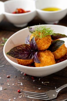 Homemade Fried Sicilian Arancini stuffed with meat, with tomato sauce