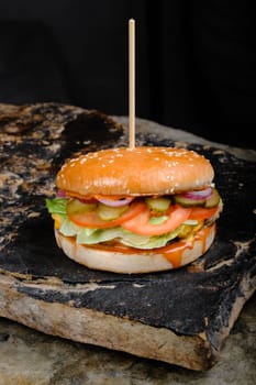 Rustic tasty Burger on Stone Background dark