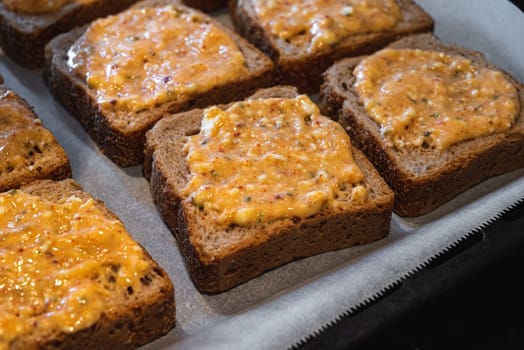 Slices of toasted bread covered with a mixture of egg and feta cheese