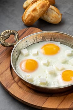 Sunny Side Up Eggs with feta cheese in a copper pan