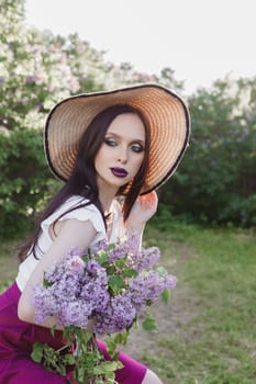 A fashionable girl with dark hair, a spring portrait in lilac tones in summer. Bright professional makeup