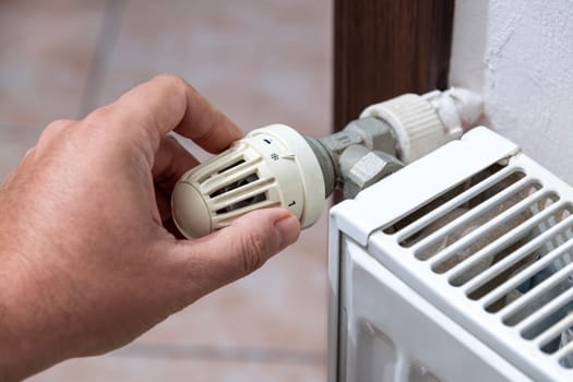 The hand that closes the radiator valve of the boiler in Europe, where there is a shortage of natural gas due to the Russian war.