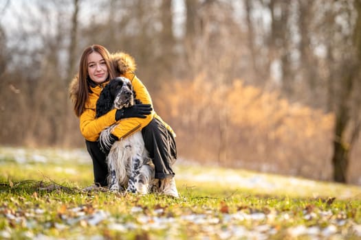 young teenage girl plays with her dog in nature. High quality photo