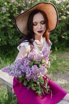 A fashionable girl with dark hair, a spring portrait in lilac tones in summer. Bright professional makeup