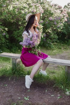 A fashionable girl with dark hair, a spring portrait in lilac tones in summer. Bright professional makeup