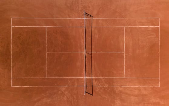 Aerial view of empty clay tennis court on a sunny day