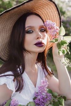 A fashionable girl with dark hair, a spring portrait in lilac tones in summer. Bright professional makeup