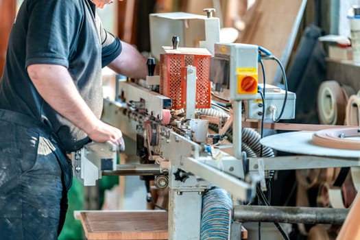 gluing the edge on a machine to a laminate board for the production of furniture in carpentry. High quality photo