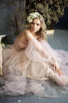 A young blonde in an airy tulle pink dress. Spring portrait of a woman