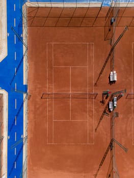 Aerial view of empty clay tennis court on a sunny day