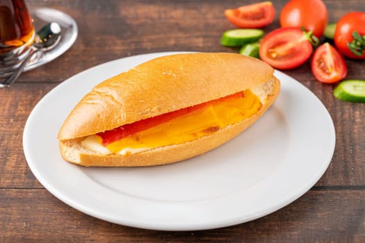 three cheese sandwich with tomato and cucumber on dark stone table