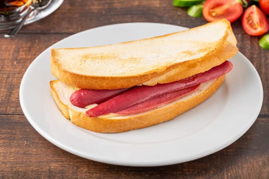 Ham, sausage and cheese sandwich on a white porcelain plate