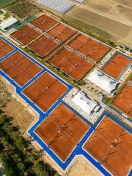 Aerial view of empty clay tennis court on a sunny day