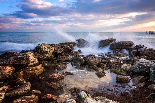 Stunning seascape with scenic clouds over the sea with rocky shore