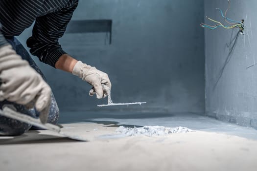 work with trowel on floor and wall in new room in building. High quality photo