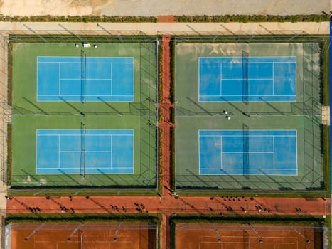 Aerial view of empty blue hard tennis court on a sunny day
