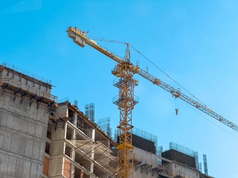 Crane used for skyscraper construction at construction site on a sunny clean day