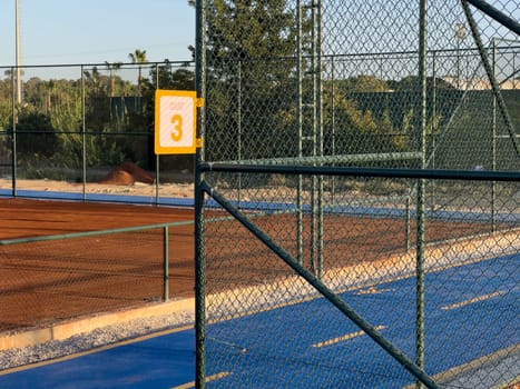 Sign showing tennis court number 3 on a sunny day