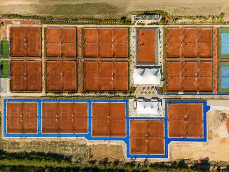 Aerial view of empty clay tennis court on a sunny day