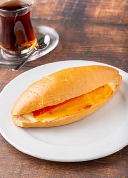 three cheese sandwich with tomato and cucumber on dark stone table