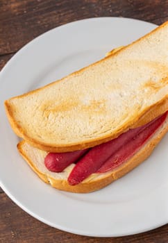 Ham, sausage and cheese sandwich on a white porcelain plate
