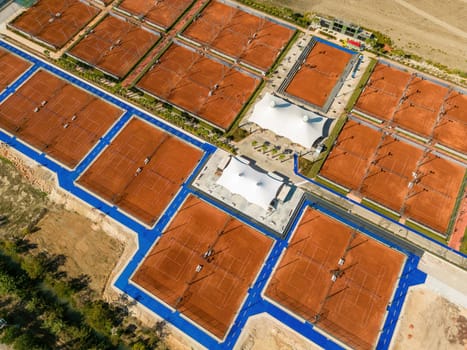 Aerial view of empty clay tennis court on a sunny day