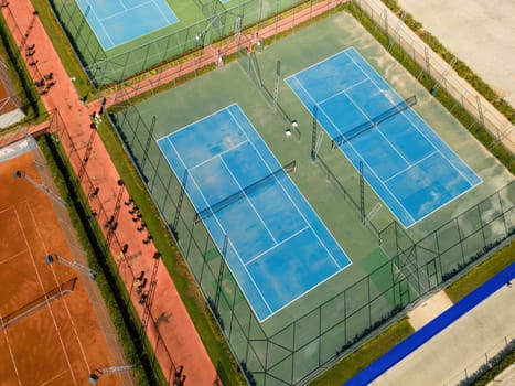 Aerial view of empty blue hard tennis court on a sunny day