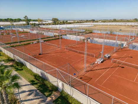 Aerial view of empty clay tennis court on a sunny day