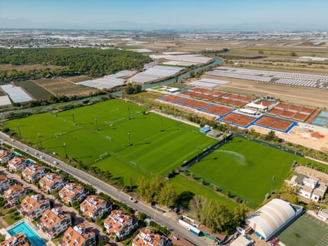 Aerial view of outdoor sports facility with football fields and tennis courts