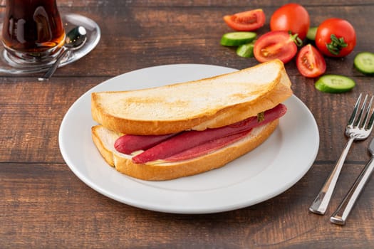 Ham, sausage and cheese sandwich on a white porcelain plate