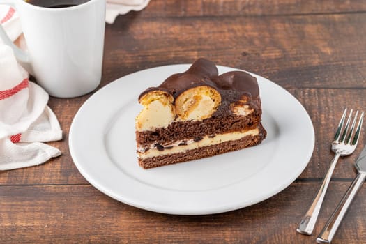 Cake with profiteroles on a white porcelain plate with filter coffee on the side