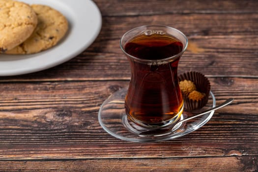 Freshly brewed black Turkish tea with cookies on wooden table