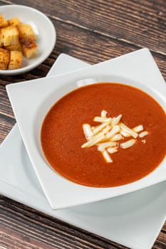 Tomato soup with cheese in white porcelain bowl