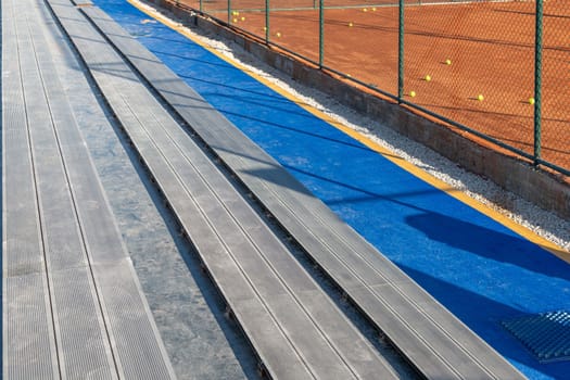 Seating area for spectators made with composite deck next to the tennis court