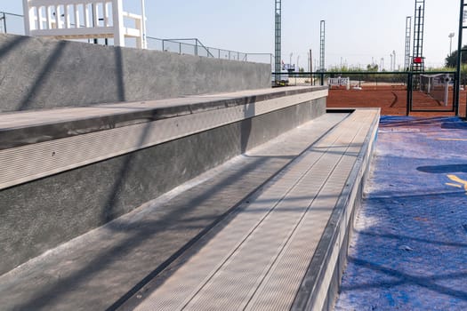 Seating area for spectators made with composite deck next to the tennis court