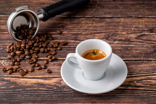 Fresh espresso coffee together decorated with coffee beans on wooden table