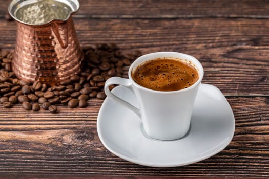 Turkish coffee in classic coffee cup with water and Turkish delight on wooden table