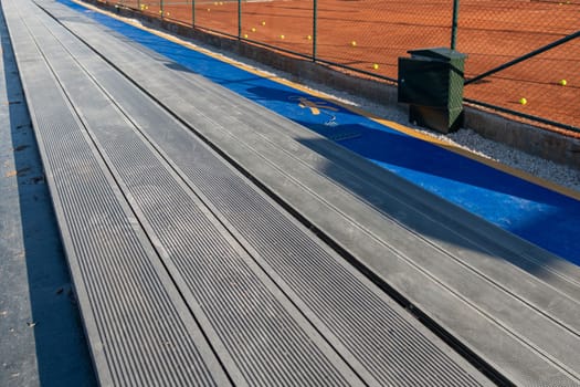 Seating area for spectators made with composite deck next to the tennis court