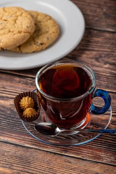 Black Turkish tea in glass cup with shortbread on wooden table