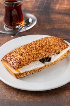 Olive and cheese sandwich with Turkish tea on wooden table