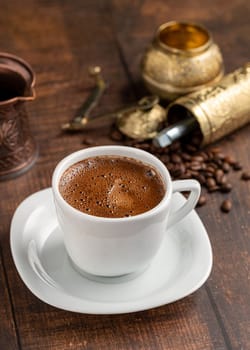 Turkish coffee in classic coffee cup with water and Turkish delight on wooden table