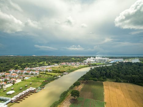 Farmland, hotel and golf courses next to the river flowing towards the sea