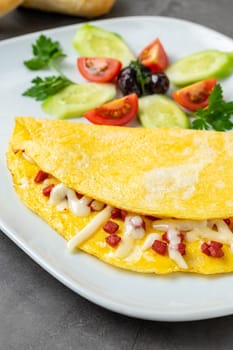 Omelet with feta cheese and Turkish sausage on a white porcelain plate