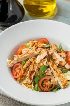 Fresh Mediterranean salad with grilled chicken breast. top view