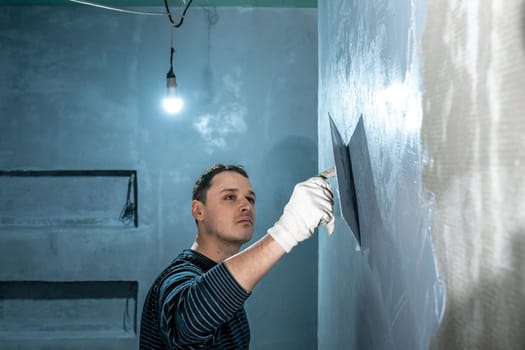 man applies insulation to a bathroom wall. 