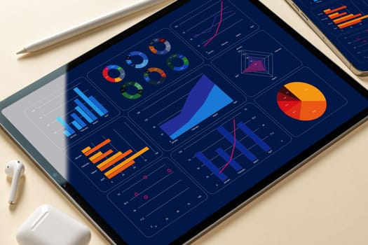 Top view of smartphone and tablet with reports and graphs on screen. office desk top view
