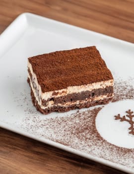 Gourmet Italian dessert tiramisu on dark wooden table