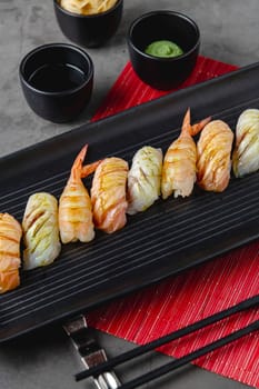 Sushi set of various products on a black stone plate