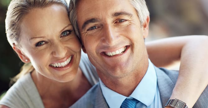It takes two to tango towards success. Cropped portrait of an affectionate mature business couple smiling and holding each other closely in front of the camera