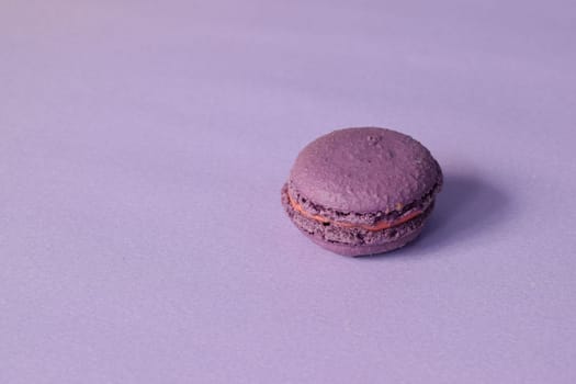 A purple macarons on a minimalistic purple background.